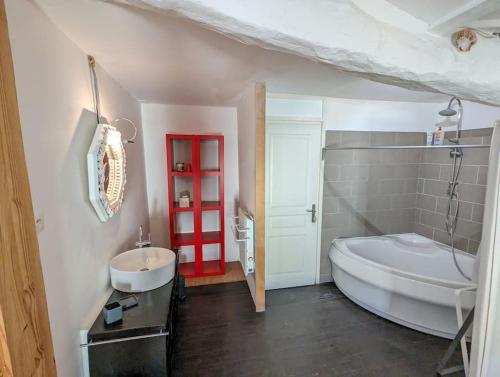 La salle de bains est pourvue d'une grande baignoire blanche et d'un lavabo. dans l'établissement Bello Viso, proche Saint Emilion, à Belvès-de-Castillon