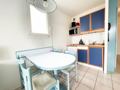una pequeña cocina con mesa blanca y sillas en Studio à 2 pas de la plage, en Urrugne