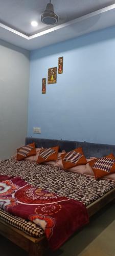 Una cama grande en una habitación con almohadas. en Bhagwati Guest House Ujjain, en Ujjain