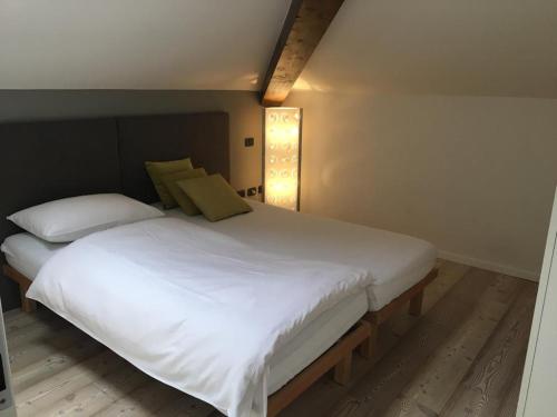 ein Schlafzimmer mit einem großen weißen Bett mit zwei Kissen in der Unterkunft Appartamento i Sentieri 23 in Riva del Garda