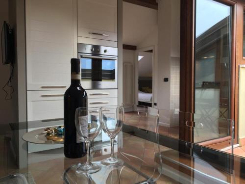 una bottiglia di vino e due bicchieri da vino su un bancone di Appartamento i Sentieri 23 a Riva del Garda