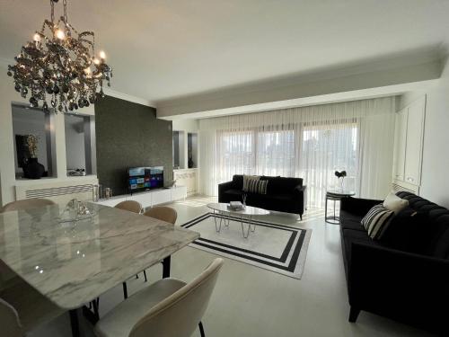 a living room with a dining table and a chandelier at Kaplan Luxury Flat - 3 Bedrooms with air conditioning & heating in the City in Istanbul