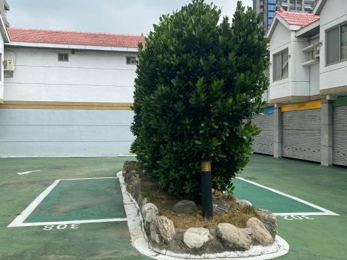 een kleine boom op een parkeerplaats naast een garage bij Yuan Chyau Motel in Taichung