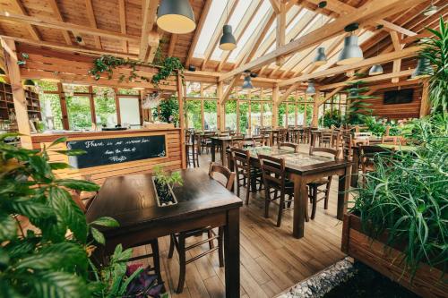 un restaurante con mesas de madera, sillas y plantas en Garden Village Bled, en Bled