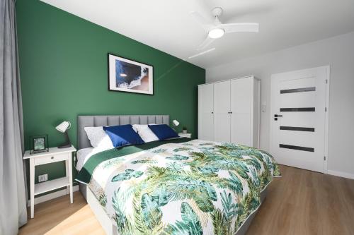 a bedroom with a bed and a green wall at Apartament Baltic Breeze ProstyWynajem Gdańsk Brzeźno in Gdańsk