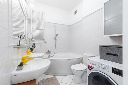 biała łazienka z umywalką i pralką w obiekcie SuperApart Relaksowa 37 w Warszawie