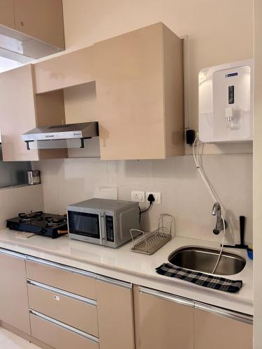 a kitchen with a microwave and a sink at Good Stay Pool view stylish Studio Apartment,6km from Airport, 307 in Dabolim
