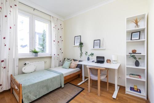 een slaapkamer met een bed en een bureau met een laptop bij SuperApart Relaksowa 37 in Warschau