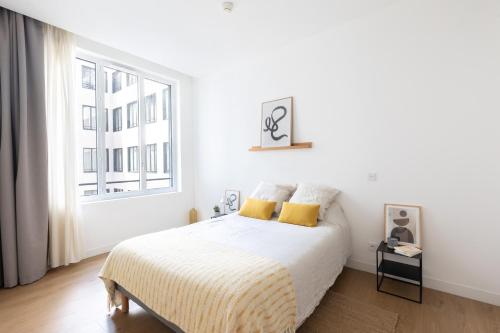- une chambre blanche avec un lit et une fenêtre dans l'établissement Les Appartements de Babel Vieux Port, à Marseille