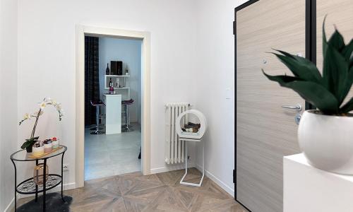 a room with a hallway with a plant and a mirror at Triumvirato Rooms in Bologna