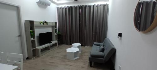 a living room with a couch and a television at Singgahsini Guesthouse Putrajaya in Putrajaya