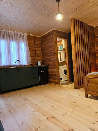 sala de estar con cocina y suelo de madera en inSxvava, en Ambrolauri