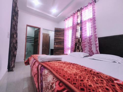 a bedroom with a bed with a red comforter and a window at Hotel Yolo in Chandīgarh