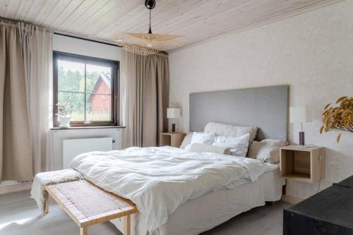 a white bedroom with a large bed and a window at A countryside villa close to Uppsala! in Uppsala