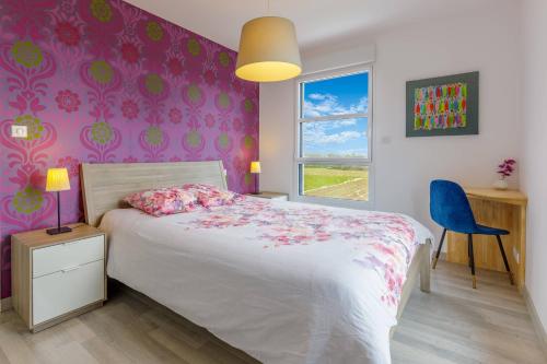 a bedroom with a bed and a purple wall at Villa Yana Bretagne Piscine Intérieure partagée et Spa Privatif 100m de la Plage in Sibiril