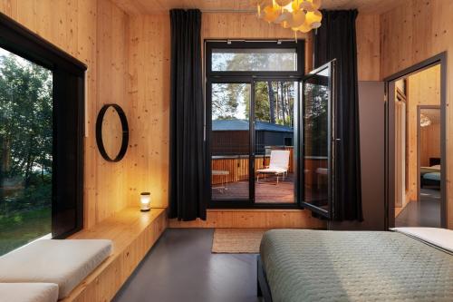 a bedroom with two beds and a large window at Elf am See - Haus 10 in Templin
