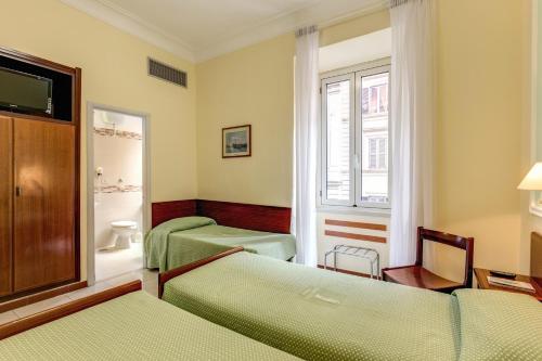 una camera d'albergo con due letti e un bagno di Hotel Igea a Roma
