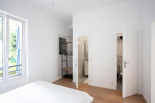 een witte slaapkamer met een bed en een raam bij Luxury apartment Alfortville in Alfortville
