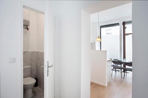 uma casa de banho branca com WC e uma sala de jantar em Luxury apartment Alfortville em Alfortville