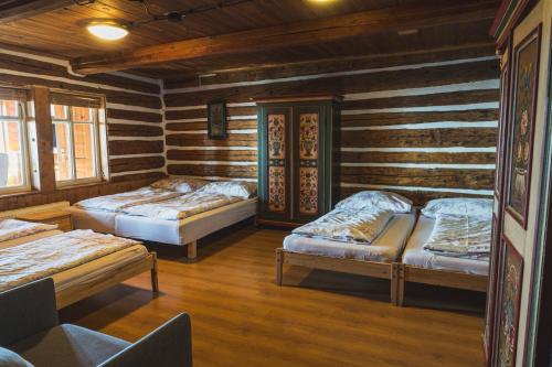 a room with three beds in a log cabin at Bouda Matouš - Friesovy boudy in Strážné