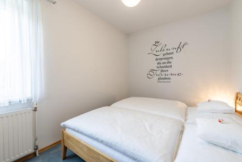 a small bedroom with a bed with white sheets at Pension Klug Adults only - DorfResort Mitterbach in Mitterbach