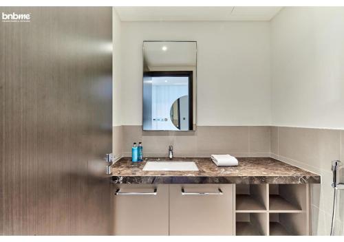 La salle de bains est pourvue d'un lavabo et d'un miroir. dans l'établissement bnbmehomes - Breathtaking Downtown Views at BLVD - 3801, à Dubaï