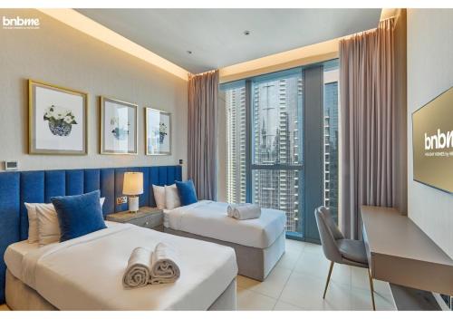 een hotelkamer met 2 bedden en een raam bij bnbmehomes - Breathtaking Downtown Views at BLVD - 3801 in Dubai