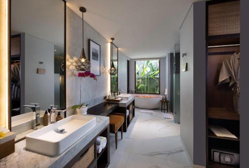 uma casa de banho com 2 lavatórios e uma banheira em The Hava Ubud A Pramana Experience em Ubud