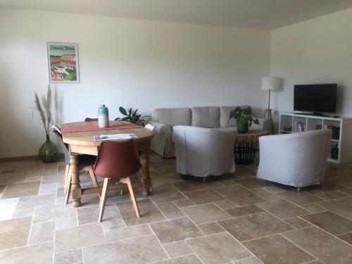 ein Wohnzimmer mit einem Sofa und einem Tisch in der Unterkunft Chambres d’hôtes Arremounon in Lamothe