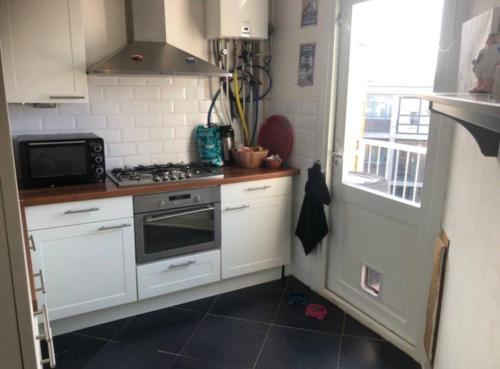 een kleine keuken met een fornuis en een magnetron bij Nice apartment next to the beach in Scheveningen