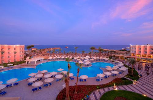 an overhead view of a pool with umbrellas and the ocean at Beach Albatros The Club - Aqua Park in Hurghada