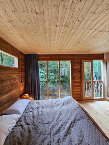 a bedroom with a large bed with a wooden ceiling at inSxvava in Ambrolauri