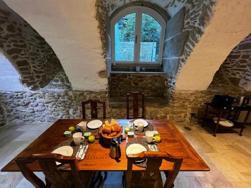 a dining room with a wooden table in a building at Les Remparts in Mirepoix