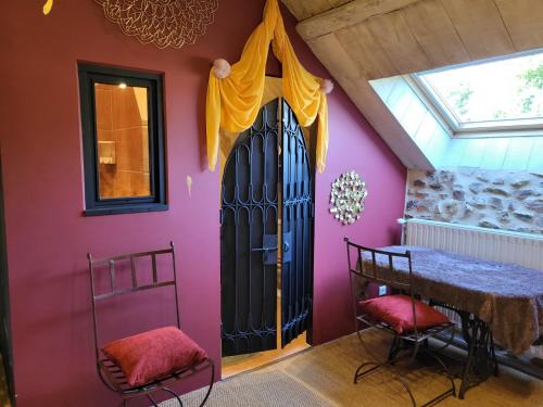 um quarto com uma porta preta e uma parede rosa em Les Causeries du Monde em Chamboulive