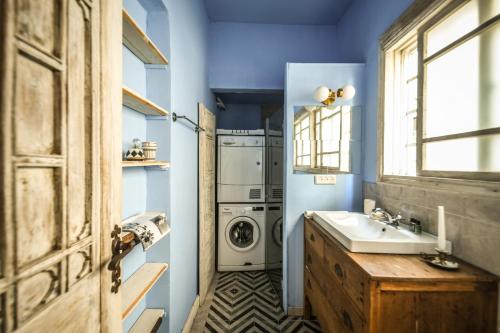 een badkamer met een wasmachine en een wastafel bij Rustic 1 BR Apt w Cozy Backyard in City Center by Sea N' Rent in Tel Aviv