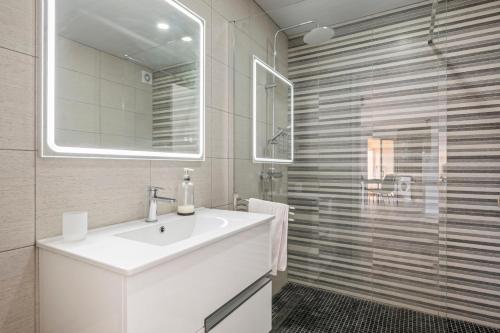 a white bathroom with a sink and a shower at Magical Sunset in Madalena do Mar