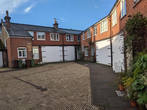 ロイヤル・タンブリッジ・ウェルズにあるLovely Stable mews in hidden locationのレンガ造りの建物前の空き駐車場