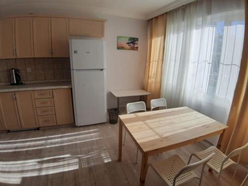 uma cozinha com uma mesa e um frigorífico branco em Lara Beach 600 m, 80 m2 flat, 2 bedroom, Netflix em Antalya