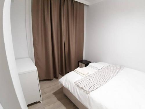 um quarto com uma cama branca e uma janela em Lara Beach 600 m, 80 m2 flat, 2 bedroom, Netflix em Antalya