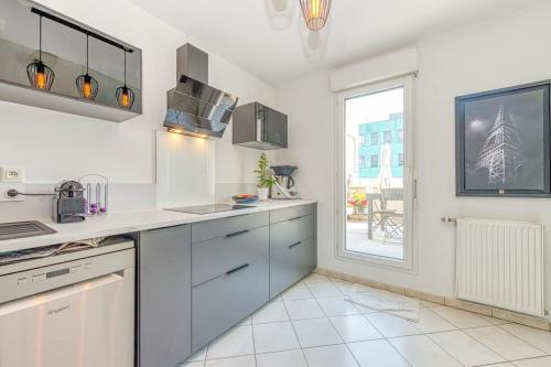 a kitchen with white appliances and a large window at Standing, balcon avec vue, clim, tt équipé confort in Échirolles