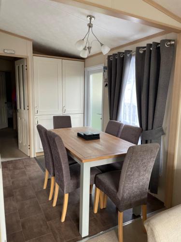 a dining room with a wooden table and chairs at Freedom Lodge - Aviemore with FREE Starlink Superfast broadband 150mbps - Pet Free in Aviemore