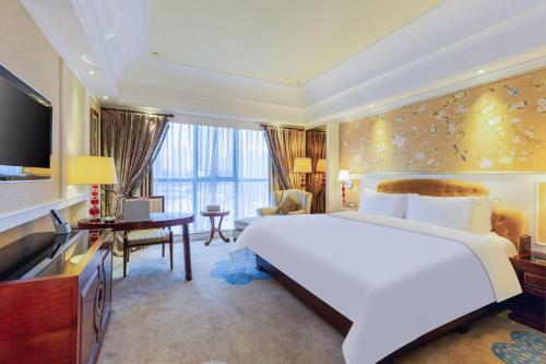 a bedroom with a large white bed and a desk at WYNDHAM Foshan shunde in Shunde