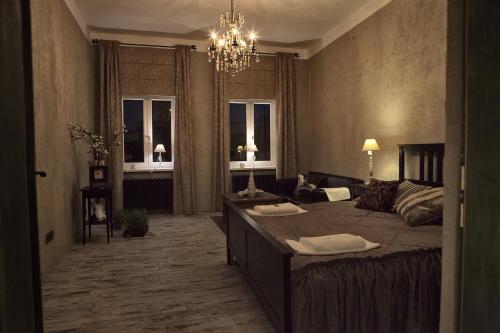 a bedroom with a large bed and a chandelier at Apartments Rose Garden in Děčín