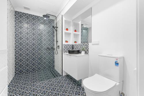 a bathroom with a toilet and a shower at Villa Vaucluse Apartments in Cairns