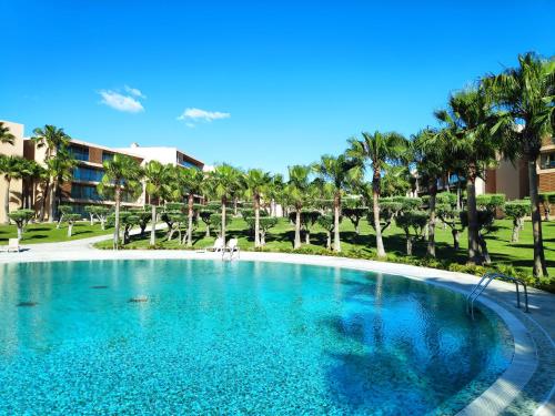 uma grande piscina num resort com palmeiras em Salgados Beach&Golf - Praia dos Salgados em Albufeira