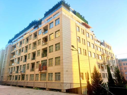 un grand bâtiment jaune avec des plantes en haut dans l'établissement City Center 2BDR apartment near Rustaveli Av., à Tbilissi
