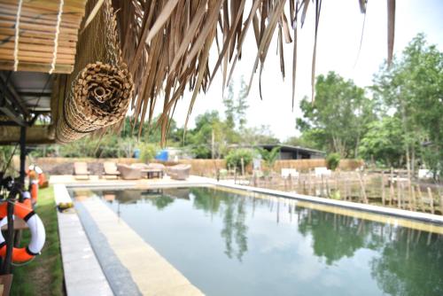 a swimming pool in a resort with a hammock at TimeOut Island Glamping Resort in Ấp Binh Trung