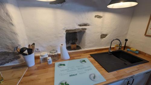 a kitchen with a sink and a sign on a counter at Silent River - Mosel in Bruttig-Fankel