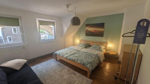 a bedroom with a bed and two windows at Silent River - Mosel in Bruttig-Fankel