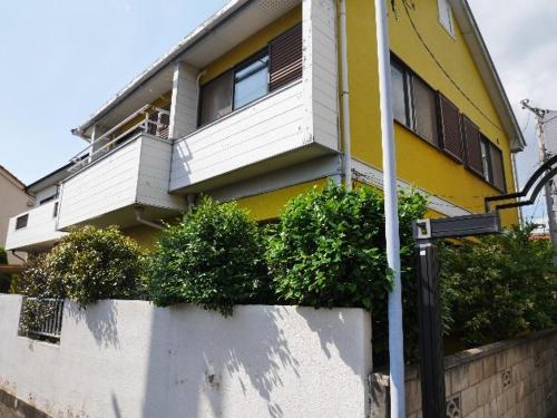 uma casa amarela e branca com plantas à sua frente em homelike / Vacation STAY 33817 em Chiba
